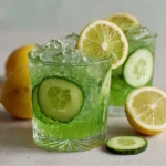 Lemons, cucumbers, honey, mint, and water arranged on a kitchen counter